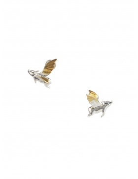 Silver earrings with a flying pig on the earlobe